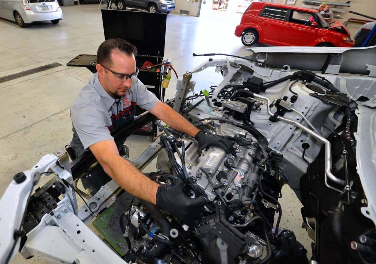 Collision technician repairing the front structure of a vehicle