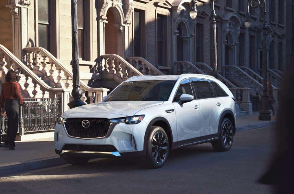 A Mazda CX-90 Family SUV parked in front of some classic architecture