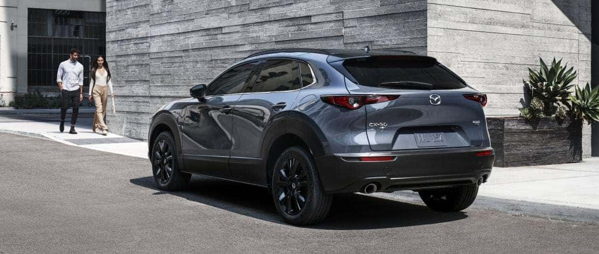 A gray 2025 Mazda3 hatchback viewed from the rear, showcasing its sleek design and distinctive taillights.