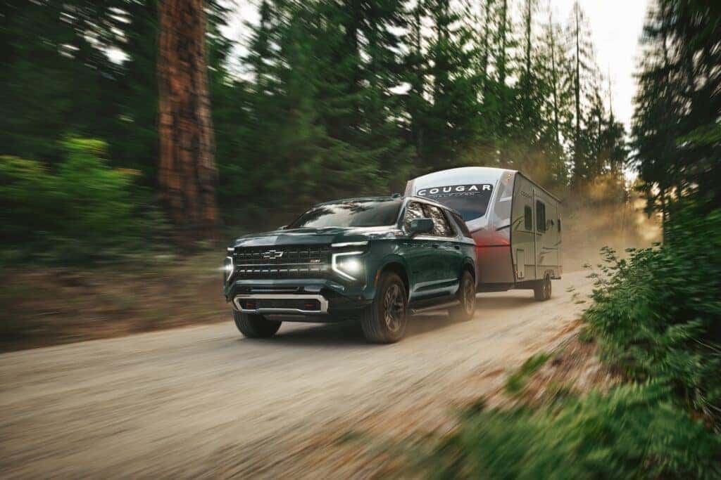 Front 3/4 angle in motion of 2025 Chevrolet Tahoe Z71 in Cypress Gray trailering.