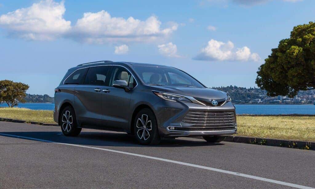 Toyota Sienna Driving on a Road Beside a Lake Front 3/4 View