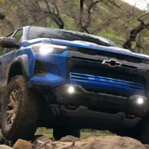 2026 Chevrolet Colorado ZR2 Reef Blue Metallic driving over rocks