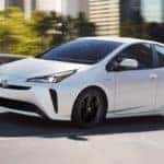 White 2020 Toyota Prius Limited driving on city street